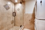 Master bathroom with glass shower and private washer and dryer